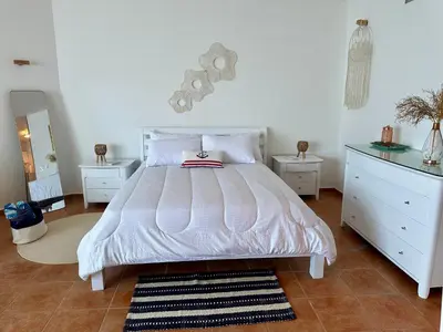 a bedroom with a white bed and two night stands at Apartamento l Vista al Mar Albatros BY JU Juan Dolio in Juan Dolio