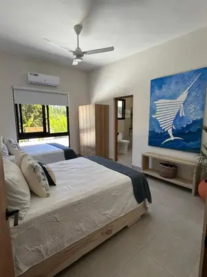 a bedroom with a large bed and a painting on the wall at Villa Antonia Spectacular Private Stay with Pool, Just Steps from the Beach, Housekeeping & Kitchen in Exclusive Gated Community in Las Terrenas