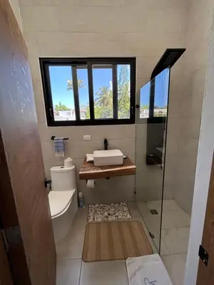 a bathroom with a toilet and a sink and a window at Villa Antonia Spectacular Private Stay with Pool, Just Steps from the Beach, Housekeeping & Kitchen in Exclusive Gated Community in Las Terrenas