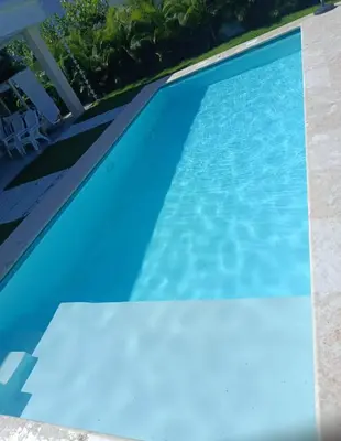 a swimming pool with blue water at Villa Antonia Spectacular Private Stay with Pool, Just Steps from the Beach, Housekeeping & Kitchen in Exclusive Gated Community in Las Terrenas