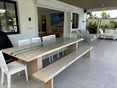 a wooden table and bench on a patio at Villa Antonia Spectacular Private Stay with Pool, Just Steps from the Beach, Housekeeping & Kitchen in Exclusive Gated Community in Las Terrenas