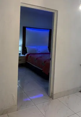 a bedroom with a bed with blue lights on the floor at Bello y acogedor Apartamento in Santiago de los Caballeros