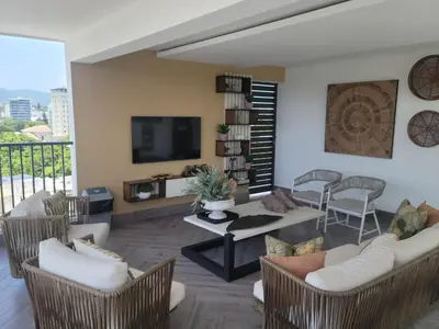 a living room with chairs and a table and a tv at Luxury Apartment Downtown in Santiago de los Caballeros