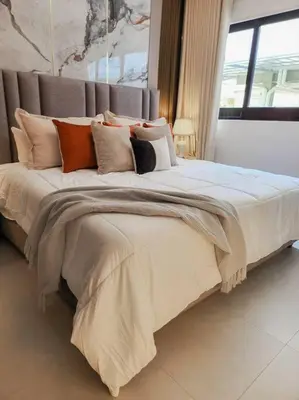 a bedroom with a large bed with many pillows at Luxury Apartment Downtown in Santiago de los Caballeros