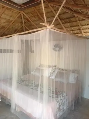 a bedroom with a canopy bed with white curtains at EL Cielo de Cana in Las Terrenas