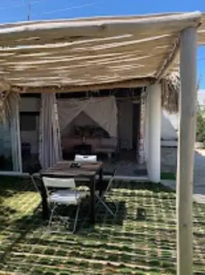 a patio with a table and chairs under a roof at EL Cielo de Cana in Las Terrenas