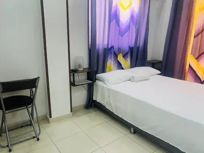 a small room with a bed and a chair at Fantástico y pequeño estudio in Santiago de los Caballeros