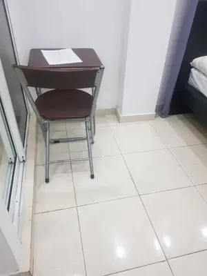 a table and a chair sitting on a tiled floor at Fantástico y pequeño estudio in Santiago de los Caballeros