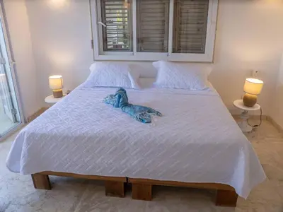 a blue teddy bear is laying on a bed at JandalaVillage in Las Terrenas