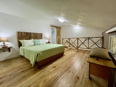 a bedroom with a bed and a wooden floor at Ballenas beach C8 in Las Terrenas