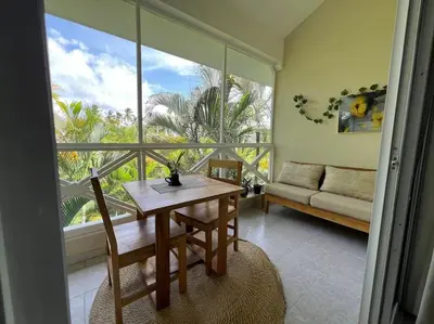 a living room with a table and a large window at Ballenas beach C8 in Las Terrenas