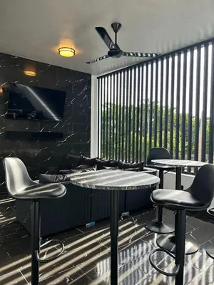 a bar with two tables and chairs and a large window at Level suites Penthouse in Sosúa