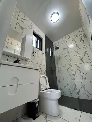 a white bathroom with a toilet and a shower at Level suites Penthouse in Sosúa