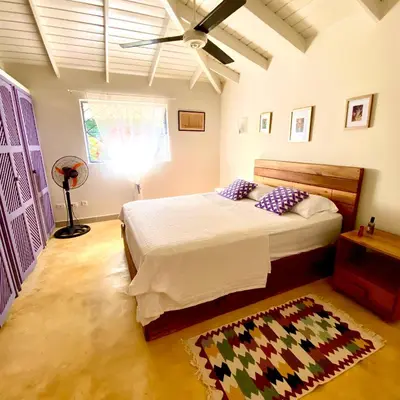 a bedroom with a bed and a ceiling fan at Casa Del Sol in El Limón