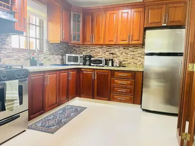 a kitchen with wooden cabinets and stainless steel appliances at Cozy 2 bed apartment garden views close to Playa Bavaro in Punta Cana
