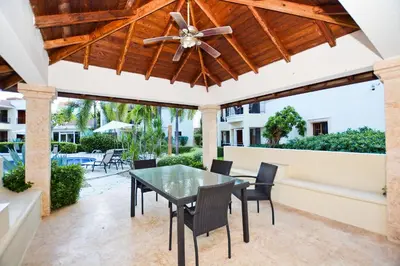 a patio with a table and chairs and a ceiling fan at Cozy 2 bed apartment garden views close to Playa Bavaro in Punta Cana