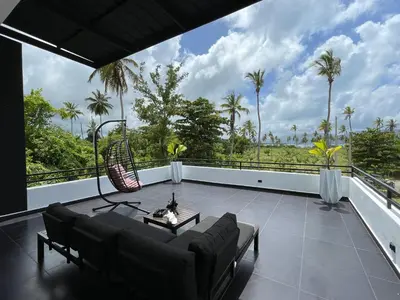 a living room with a couch and a table on a balcony at Casa black and white frente al mar in Las Galeras