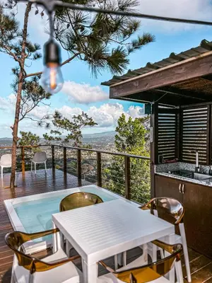 a white table and chairs on a deck with a view at The Domes Jarabacoa in Jarabacoa