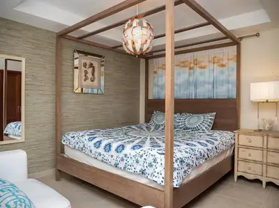 a bedroom with a canopy bed and a chandelier at SuiteDelux Oceanview Marbella 3BDR in Juan Pedro