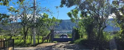 a sign for a blue mountain sign with a fence at BlueEcolandia bungalows AIRE in Jarabacoa