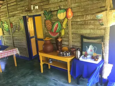 a room with a table and a wall with paintings at Los Bohios Campo Añil in Jarabacoa
