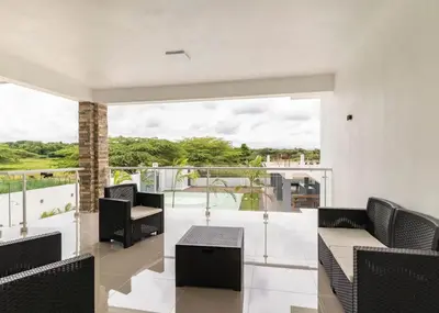 a balcony with black chairs and a large window at Modern Vacation Paradise Villa with Private Pool in Sosúa