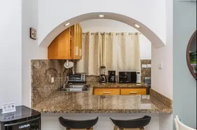 a kitchen with an archway over a counter with a sink at El Neptuno Residencial, Sosua in Sosúa