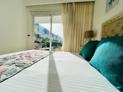 a bedroom with a large bed with a large window at Paradise Pool Front and Beach Condo at Punta Cana in Punta Cana