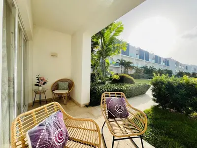 a patio with two wicker chairs and a table at Paradise Pool Front and Beach Condo at Punta Cana in Punta Cana
