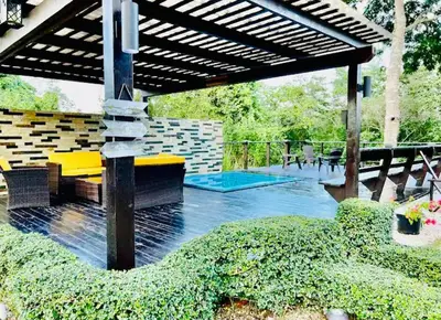 a covered patio with a bench and a table at Río Privado Villa Jarabacoa con Picuzzi in Jarabacoa