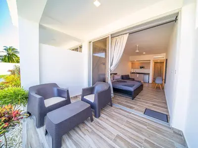 a balcony with chairs and a couch and a living room at Encuentro Studio surf kitesurf Residencia Aris in Cabarete