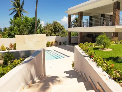 a house with a swimming pool and a yard at Encuentro Studio surf kitesurf Residencia Aris in Cabarete