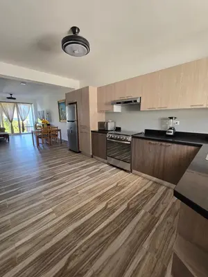 a kitchen with wooden floors and a kitchen with a refrigerator at ENCUENTRO 2 BR, Surf, kiting, home Residencial Aris in Cabarete