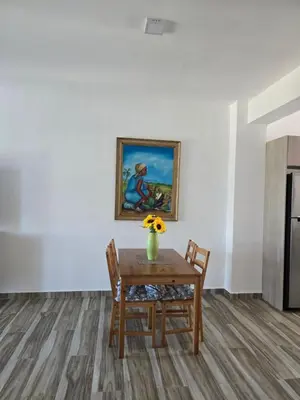 a dining room table with a vase of flowers on it at ENCUENTRO 2 BR, Surf, kiting, home Residencial Aris in Cabarete
