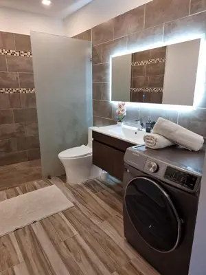 a bathroom with a washer and a sink and a toilet at ENCUENTRO 2 BR, Surf, kiting, home Residencial Aris in Cabarete