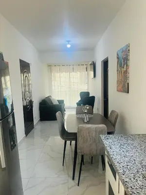 a living room with a table and chairs and a couch at Departamento Sol in Santo Domingo