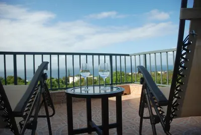 two glasses of wine sitting on a table on a balcony at E&J Boutique Residences in Sosúa