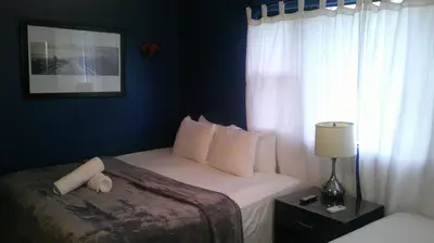 a bedroom with a bed with white pillows and a window at E&J Boutique Residences in Sosúa