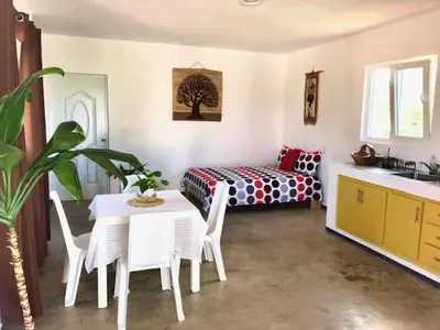 a room with a table and a bed and a table and chairs at Villa KAMBUSA in Las Galeras