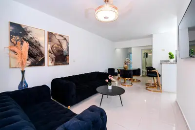 a living room with black couches and a table at Villa Campo Sosúa - Apartamento in Sosúa