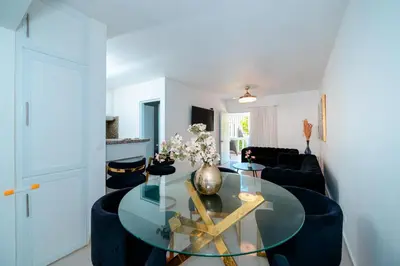 a living room with a glass table and a blue couch at Villa Campo Sosúa - Apartamento in Sosúa