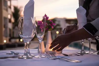 a table with wine glasses and flowers on it at Los Flamencos Aparthotel Beach Club in Bayahibe