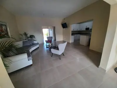 a living room with a couch and a chair and a kitchen at Villa Xiomara in El Jamo