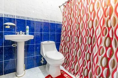 a blue tiled bathroom with a toilet and a sink at Casa para vacacionar - El patio de Olivia in San Felipe de Puerto Plata
