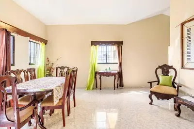 a dining room with a table and chairs and a window at Casa para vacacionar - El patio de Olivia in San Felipe de Puerto Plata