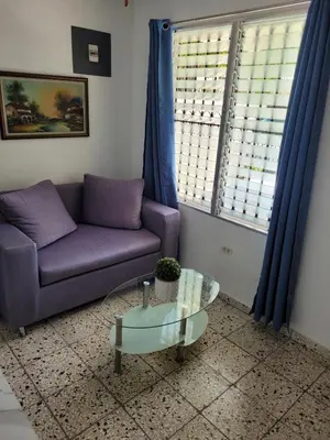 a living room with a purple couch and a glass table at Cozy Apartment Studio in Santo Domingo