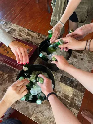 a group of people reaching for wine bottles on a table at Villa Celeste Bed & Breakfast in El Río Arriba