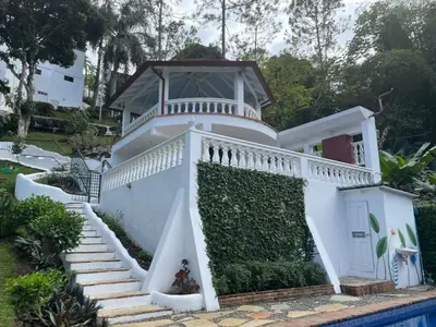 a white house with a staircase next to a pool at Villa Celeste Bed & Breakfast in El Río Arriba