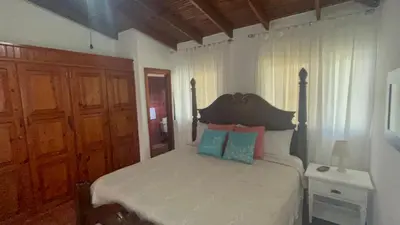 a bedroom with a bed with blue and pink pillows at Villa Celeste Bed & Breakfast in El Río Arriba