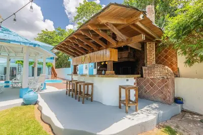 a patio with a bar with stools and a grill at Dolce Casa in Juan Dolio